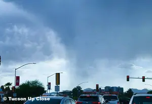 rain clouds in a city begin shedding rain