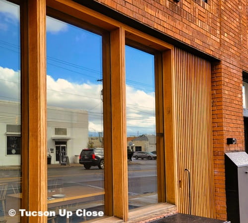 doorway into a restaurant with the picture window reflecting the city street