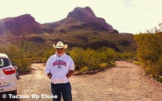 man standing on a dirt road entrance to a sanctuary park. with mountain trails.
