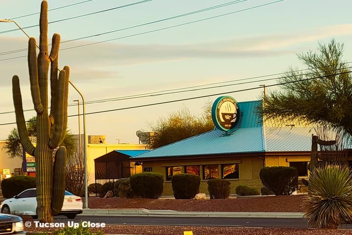 restaurant on a roadway with a saguaro cactus across the street