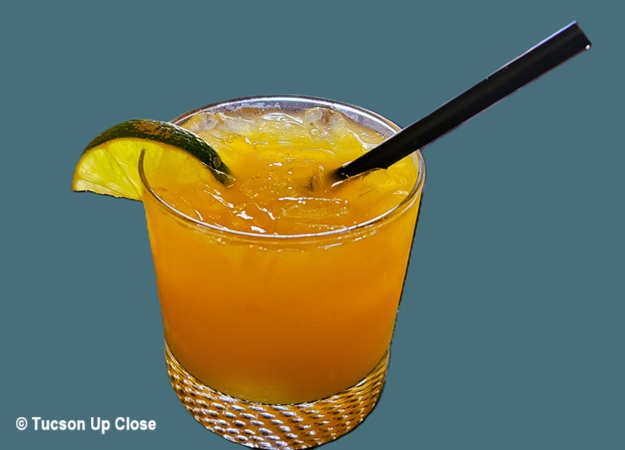 A cocktail drink in a glass amidst a solid background.