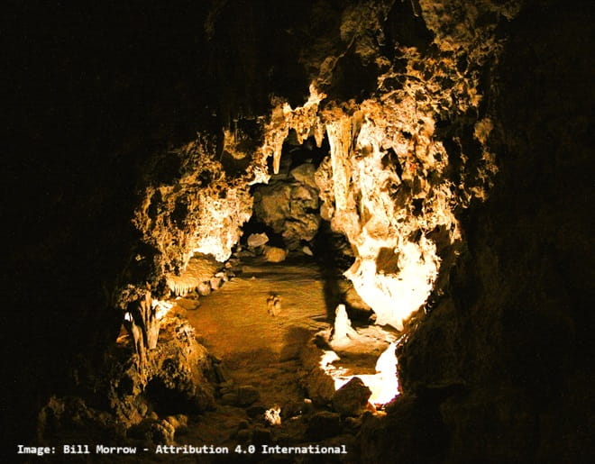 lit entry into a cave surrounded by extreme darkness