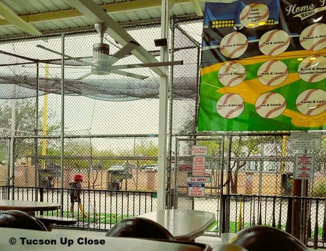 batting cages with one youngster inside taking some swings