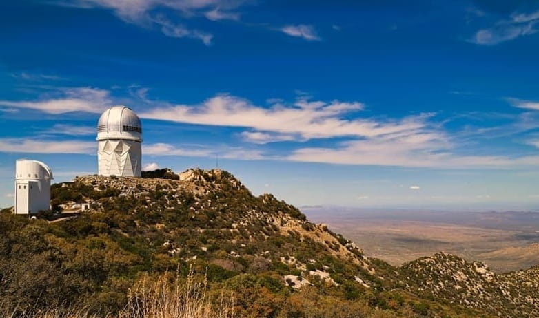 observatory telescopes on top of a mountain in the desert