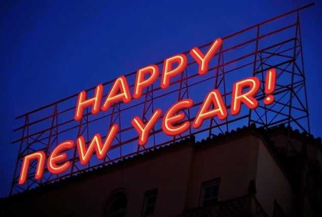 Happy New Years neon sign above a city building