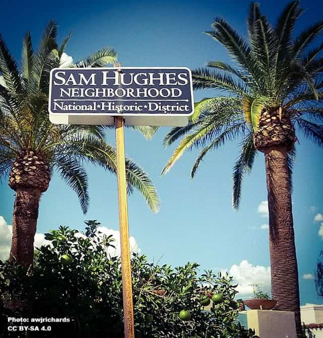 historic neighborhood sign with two palm in background