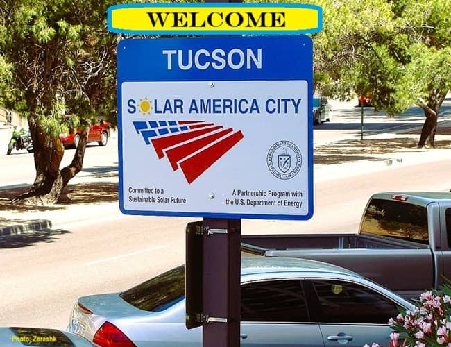 welcome sign above other sign demonstrating a solar city