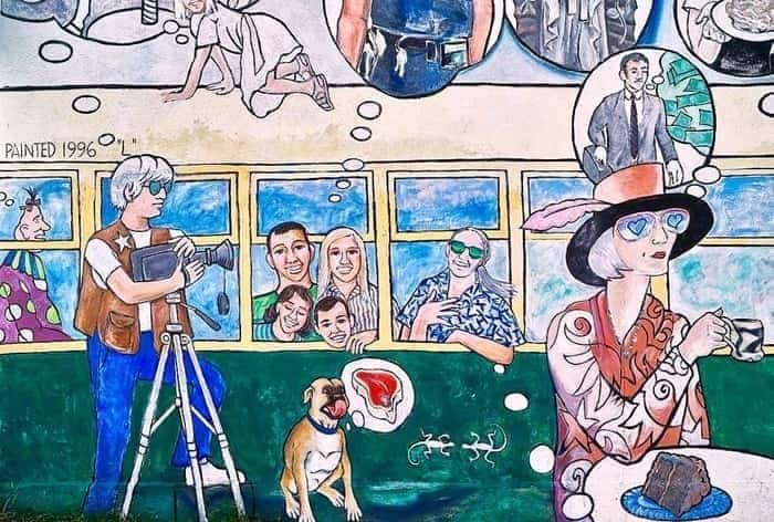 mural on a shop's wall featuring a woman at a table