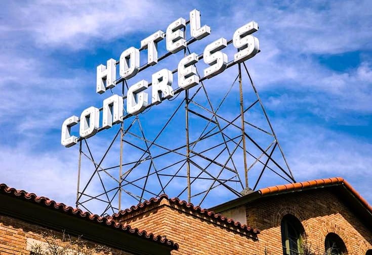 sign on top of a brick building advertising Hotel Congress in Tucson AZ